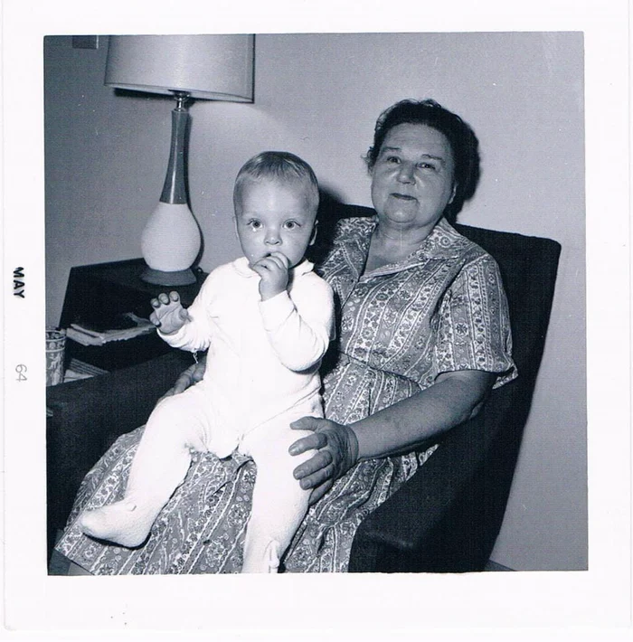 Aaron as a baby sitting on his grandmother Edith's lap in an armchair, photographed in May 1964