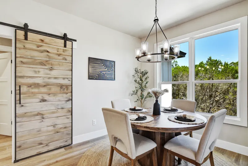 Dining room with a chandelier, round table and sliding barn door