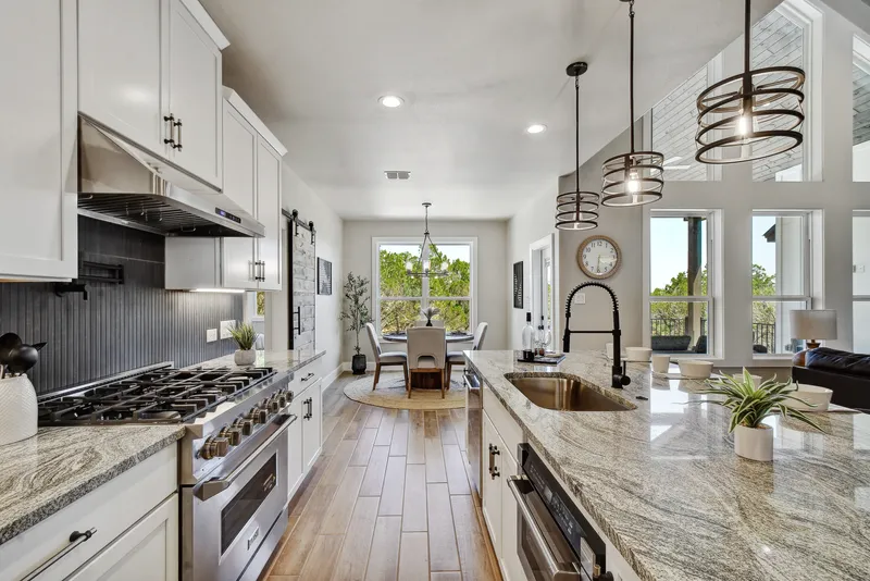Professional gas range and vent hood along a long kitchen island