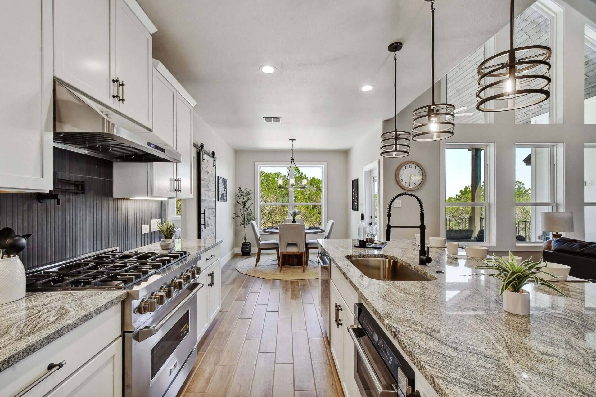 A modern kitchen featuring white cabinets and elegant granite countertops.