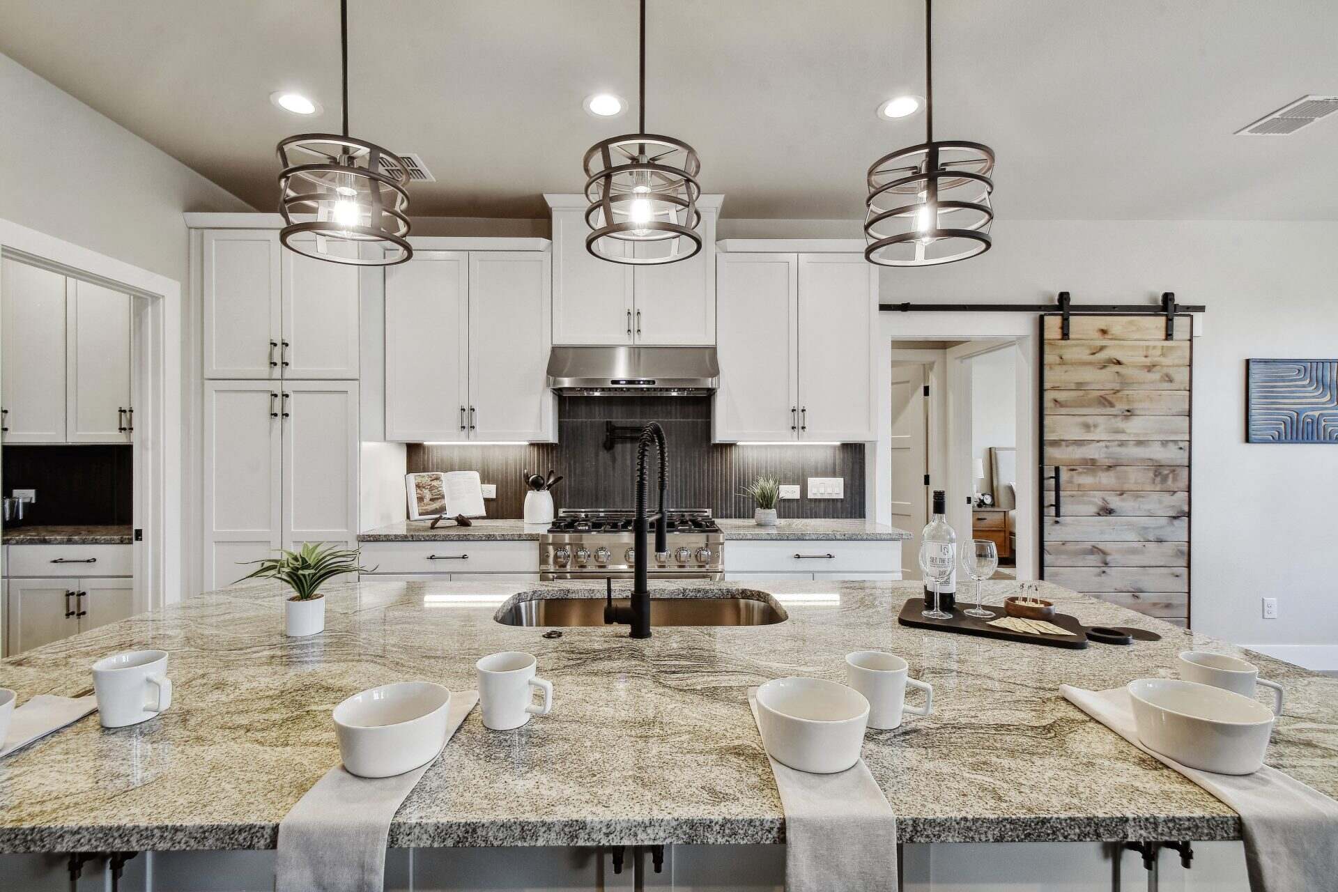 A modern kitchen featuring granite countertops and sleek white cabinets, creating a bright and elegant cooking space.